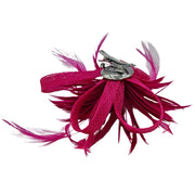 Broche-tocado de plumas en color fucsia . Mide 15 cm x 12 cm aproximadamente. En la parte trasera lleva metal plateado con alfiler para usarlo como broche y una horquilla para lucirlo en el pelo como un tocado. También puede lucirse decorando un bolso o un sombrero.