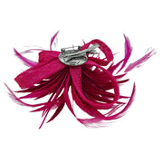 Broche-tocado de plumas en color fucsia . Mide 15 cm x 12 cm aproximadamente. En la parte trasera lleva metal plateado con alfiler para usarlo como broche y una horquilla para lucirlo en el pelo como un tocado. También puede lucirse decorando un bolso o un sombrero.