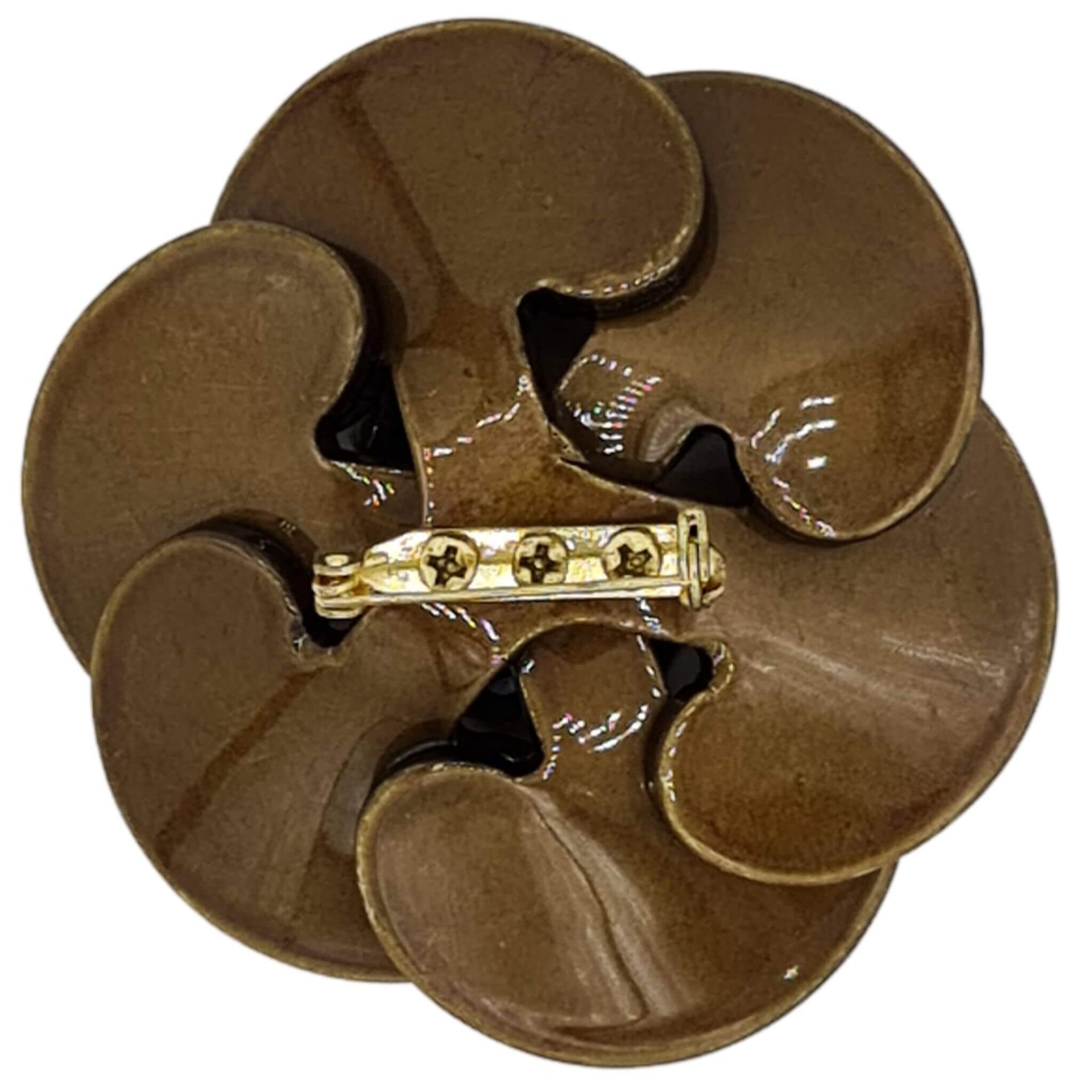 Broche flor camelia de resina brillante color kaki de 7 cm de diámetro. Cierre metálico dorado de alfiler con seguro. El complemento ideal para lucir como broche sobre la ropa, un bolso, un sombrero o un collar. Lo hay en marrón chocolate, azul, fucsia y Kaki.