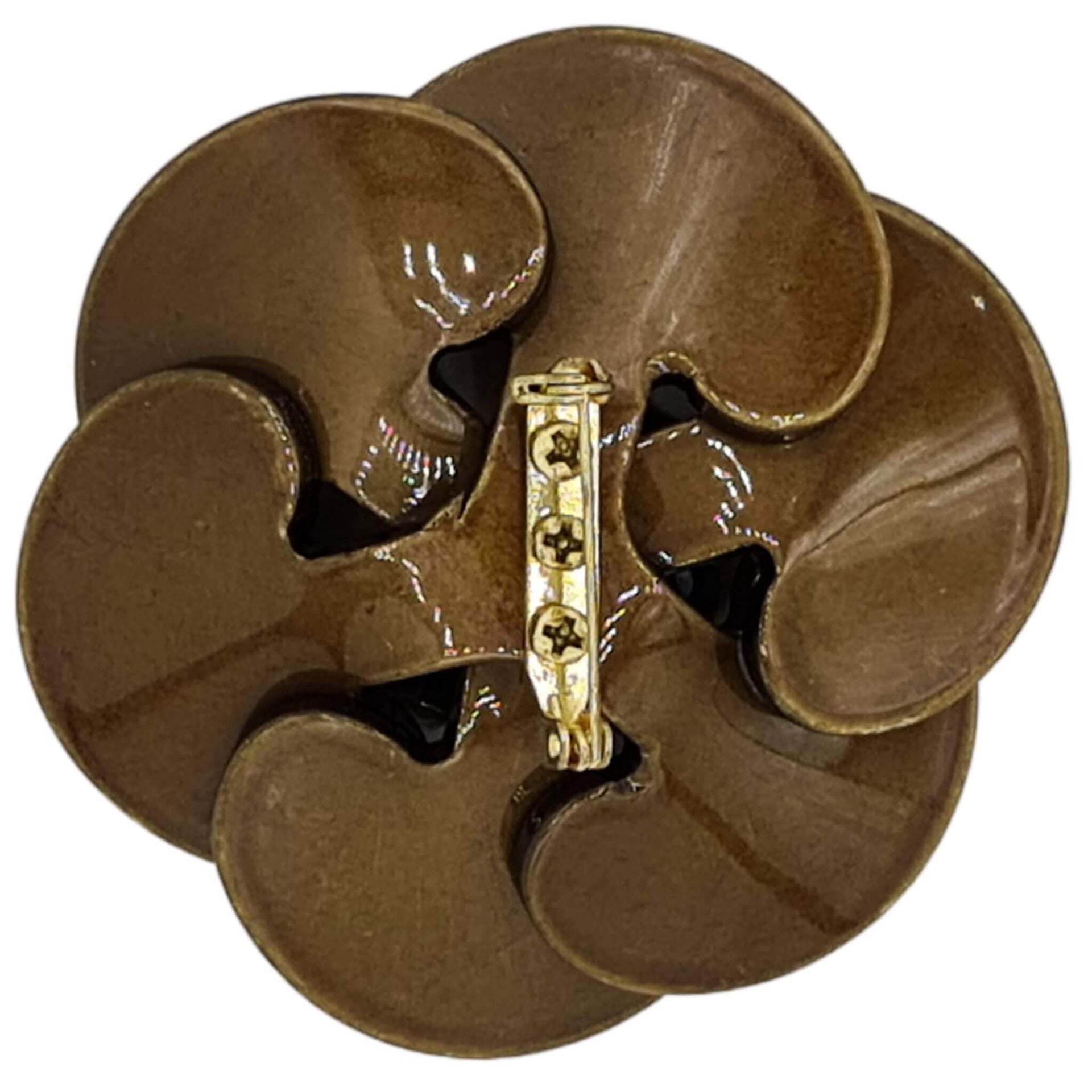 Broche flor camelia de resina brillante color kaki de 7 cm de diámetro. Cierre metálico dorado de alfiler con seguro. El complemento ideal para lucir como broche sobre la ropa, un bolso, un sombrero o un collar. Lo hay en marrón chocolate, azul, fucsia y Kaki.