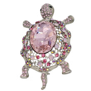 Broche de tortuga con brillantes rosas de strass y metal plateado en la parte trasera. Puede usarse también con una cadena como colgante ya que lleva una argolla en la parte superior. Mide 8 cm de largo x 5 cm de ancho.