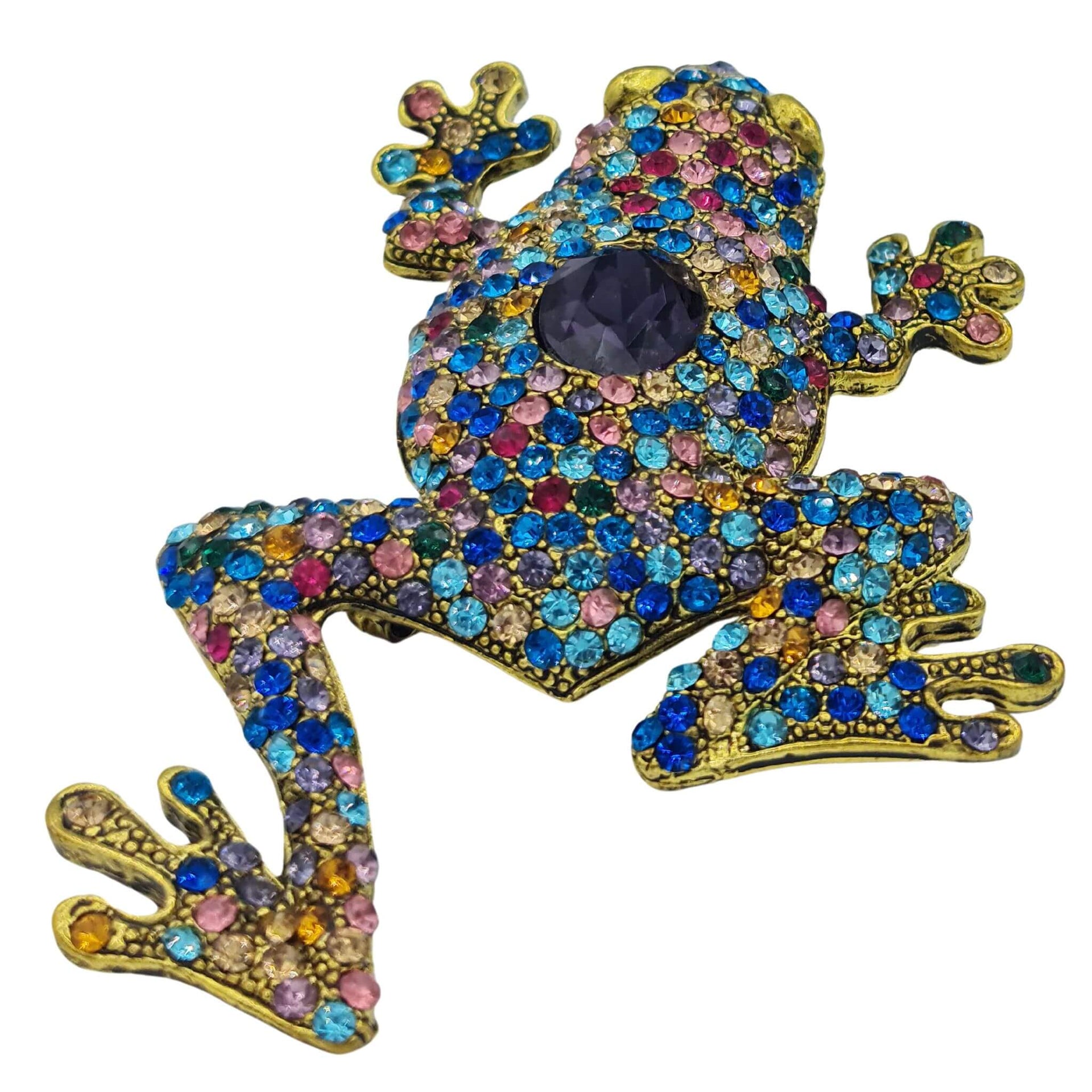 Broche rana colgante de metal dorado y brillantes de strass multicolor. Trasera en color oro viejo con alfiler y seguro.
Puede usarse también como colgante con una cadena ya que lleva una argolla en la parte superior. Mide 8 cm de largo x 5 cm de ancho.