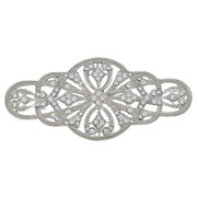 Broche alargado en metal plateado y brillantes de strass en color blanco. Mide 9 cm de largo por 4 cm de ancho. El alfiler trasero es de 6 cm con cierre de seguridad. Un complemento ideal para lucir como broche sobre la ropa, un bolso, un sombrero o un collar.