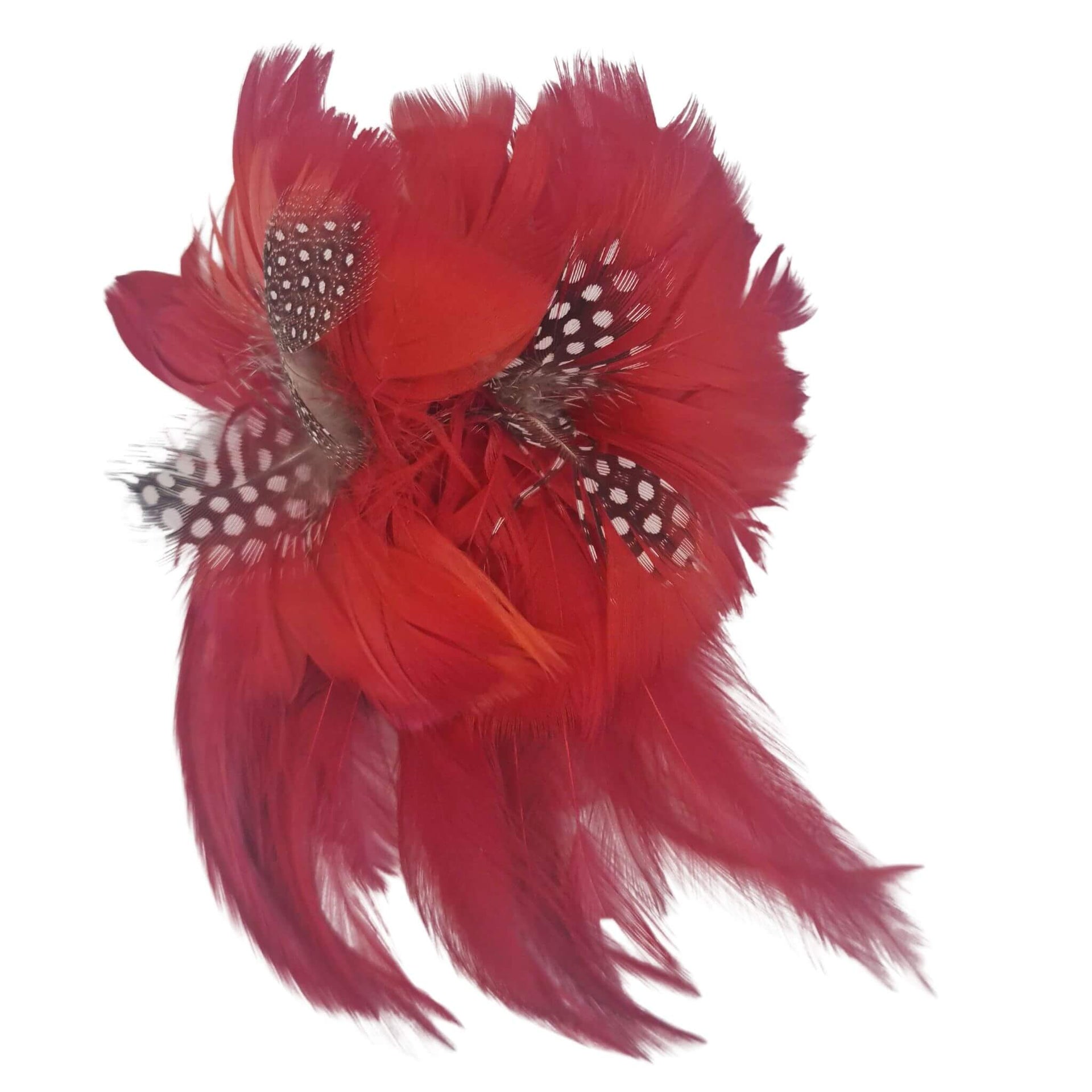 Broche-tocado de plumas en color rojo. Mide 16 cm x 12 cm aproximadamente. En la parte trasera lleva metal plateado con alfiler para usarlo como broche y una horquilla para lucirlo en el pelo como un tocado. También puede lucirse decorando un bolso o un sombrero.