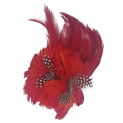 Broche-tocado de plumas en color rojo. Mide 16 cm x 12 cm aproximadamente. En la parte trasera lleva metal plateado con alfiler para usarlo como broche y una horquilla para lucirlo en el pelo como un tocado. También puede lucirse decorando un bolso o un sombrero.