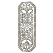 Broche rectangular en metal plateado y brillantes de strass en color blanco. Mide 8 cm de largo por 3 cm de ancho.&nbsp; El alfiler trasero es de 6 cm con cierre de seguridad. Un complemento ideal para lucir como broche sobre la ropa, un bolso, un sombrero o un collar.